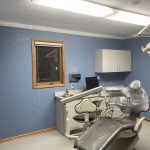 Dental chair in front of cabinets and sink