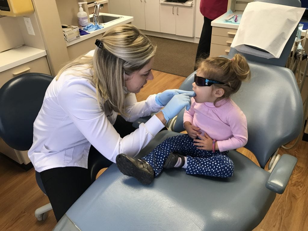 Dr. Satula examining a young girl's mouth