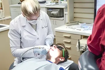 Dr. Satula using tool on patient's teeth