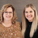 Two staff members smiling at {PRACTICE_NAME}